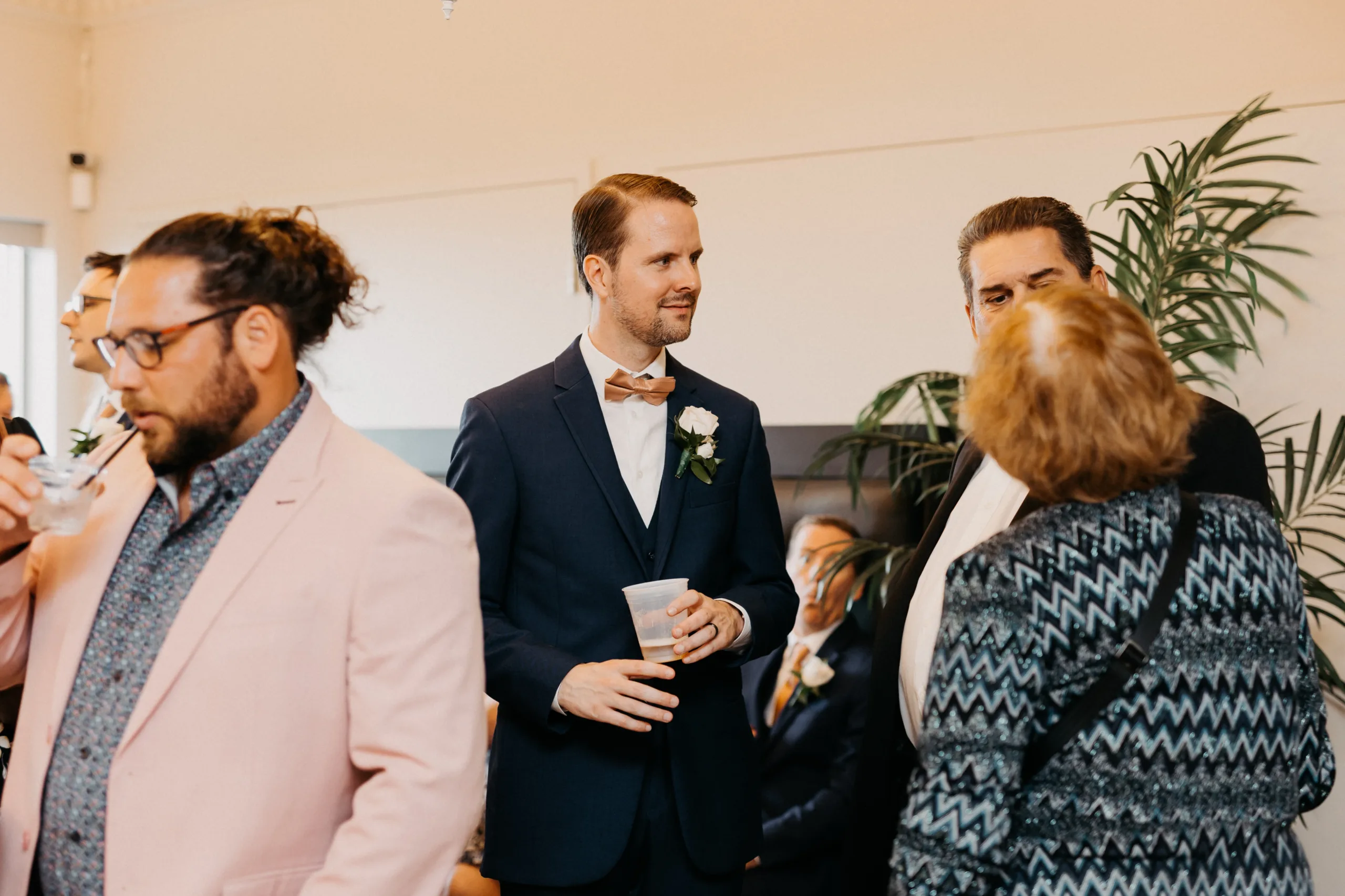 groom talking with guest at cocktail hour