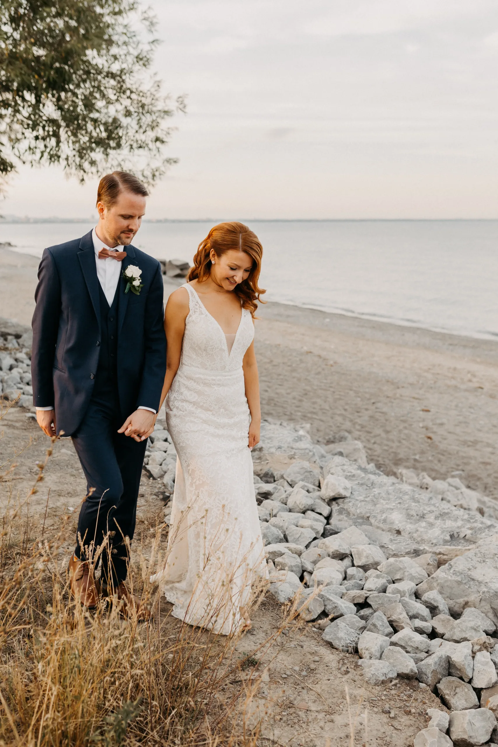 bride and groom walking waterfront